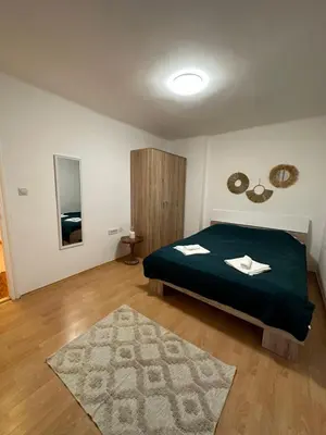 a bedroom with a green bed and a rug at Boho Apartment in Niš