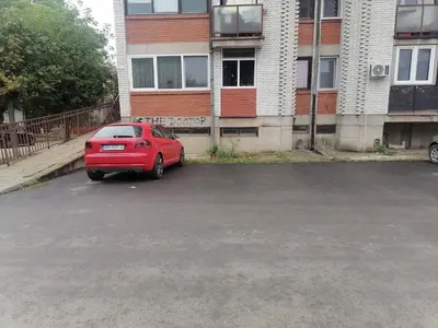 a red car parked in a parking lot next to a building at DIV Bor in Bor