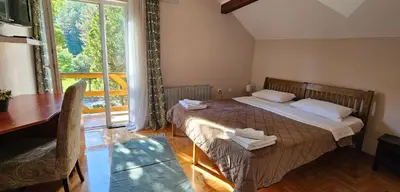 a bedroom with a bed and a table and a window at Hotel Koliba na Grza in Kilsura