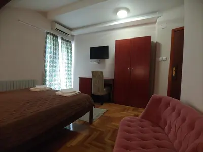 a bedroom with a bed and a couch and a television at Hotel Koliba na Grza in Kilsura