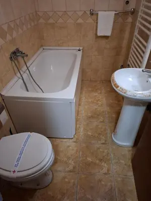 a bathroom with a toilet and a tub and a sink at Hotel Koliba na Grza in Kilsura