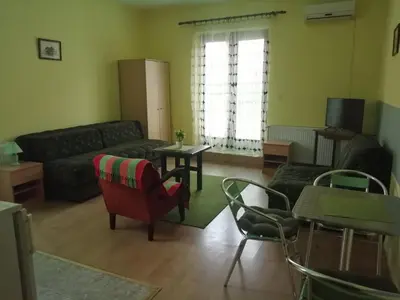 a living room with a couch and a table and chairs at Apartments Hadži in Soko Banja