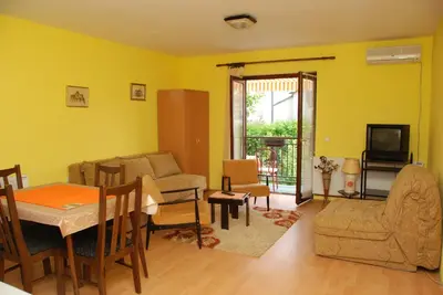 a living room with yellow walls and a table and chairs at Apartments Hadži in Soko Banja