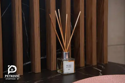 a vase with sticks in it sitting on a table at Petković apartmani 87 in Jagodina