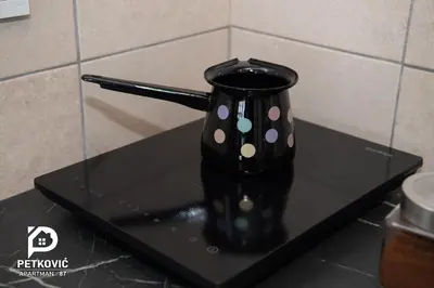 a black vase with polka dots on a black table at Petković apartmani 87 in Jagodina