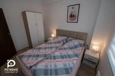 a small bedroom with a bed with a plaid blanket at Petković apartmani 87 in Jagodina
