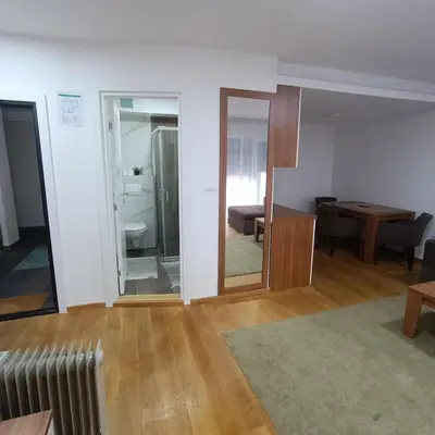 a living room with a couch and a mirror at APARTMANI PORTA INFINITAS centar in Vrnjačka Banja