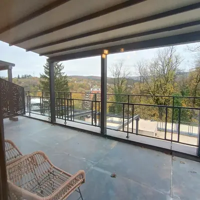 a balcony with two benches and a view of a city at APARTMANI PORTA INFINITAS centar in Vrnjačka Banja
