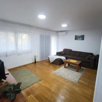 a living room with a couch and a table at APARTMANI PORTA INFINITAS centar in Vrnjačka Banja