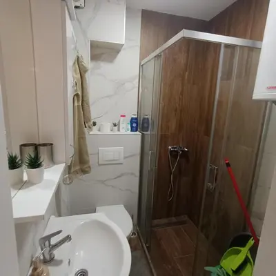 a bathroom with a shower and a sink and a toilet at APARTMANI PORTA INFINITAS centar in Vrnjačka Banja