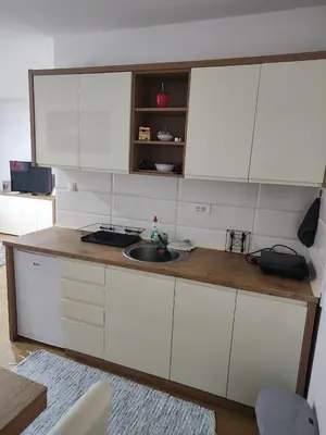 a kitchen with white cabinets and a sink at APARTMANI PORTA INFINITAS centar in Vrnjačka Banja