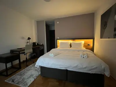 a bedroom with a large bed with a desk and a computer at Vila Simfonija in Vrnjačka Banja