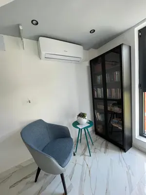 a living room with a blue chair and a table at Vila Simfonija in Vrnjačka Banja