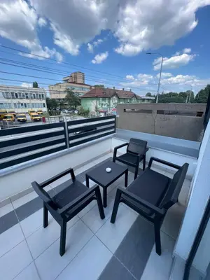 a balcony with two chairs and a table on a roof at NOMAD Apartments in Niš