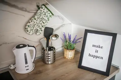 a table with a coffee maker and a picture on it at NOMAD Apartments in Niš