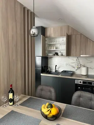 a kitchen with a table with a bowl of fruit on it at NOMAD Apartments in Niš