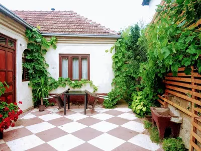 a patio with a table and chairs in a garden at Kuća iz zavičaja in Kuršumlija