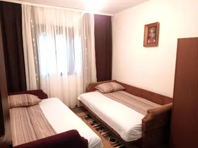 a small room with two beds and a window at Kuća iz zavičaja in Kuršumlija