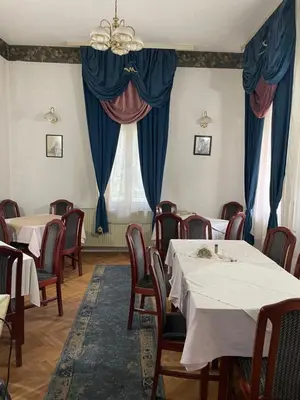 a dining room with tables and chairs and a window at Vila Grinka M in Zaječar