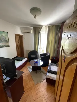 a small living room with a bed and a television at Vila Grinka M in Zaječar