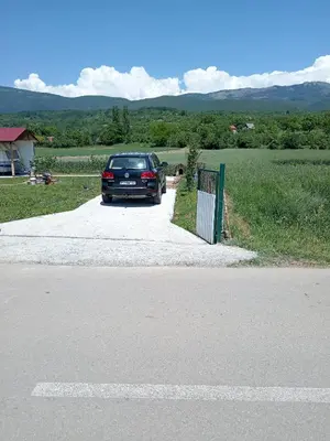a car parked in a driveway next to a fence at Apartman Sunce in Pirot