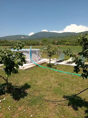a garden with a hose attached to a house at Apartman Sunce in Pirot