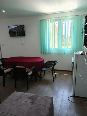 a living room with a bed and a table and chairs at Apartman Sunce in Pirot