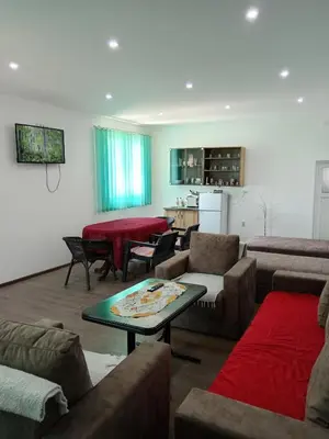 a living room with couches and a table and a kitchen at Apartman Sunce in Pirot