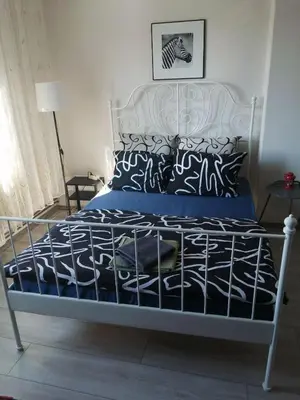 a bedroom with a bed with a blue and white comforter at Kuća Jovanka in Zaječar