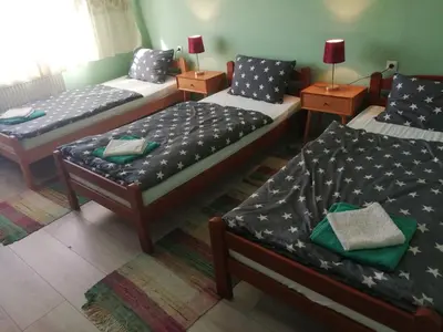 a room with three beds and two tables with lamps at Kuća Jovanka in Zaječar