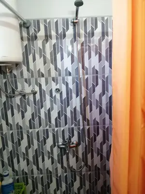 a shower with a black and white tiled wall at Kuća Jovanka in Zaječar