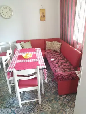 a living room with a red couch and a table at Kuća Jovanka in Zaječar