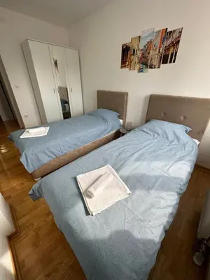 two beds sitting next to each other in a room at Nis Apartment in Niš