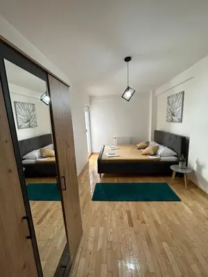 a room with two beds and a mirror in it at Nis Apartment in Niš