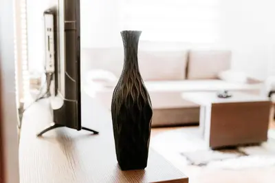 a black vase sitting on a table in a living room at Apartman Ksenija in Vrnjačka Banja