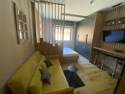 a living room with a yellow couch and a bed at Lana Lux Milmari Resort in Kopaonik