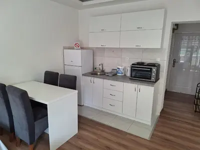 a kitchen with white cabinets and a white refrigerator at Soko apartments in Jagodina