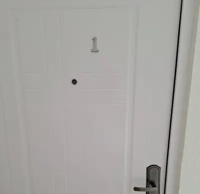 a white door with a number one on it at Soko apartments in Jagodina