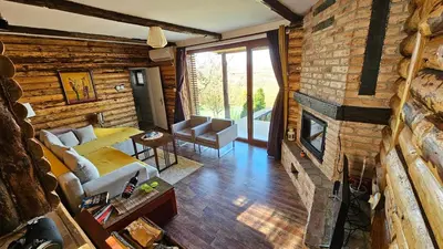 a living room with a brick wall and a fireplace at Vikendica Ristic in Knjazevac.