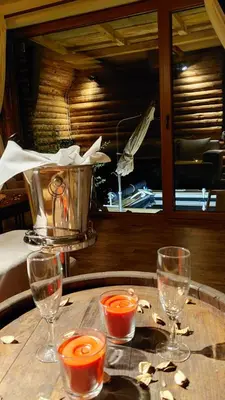 a table with three wine glasses and a bucket on it at Vikendica Ristic in Knjazevac.