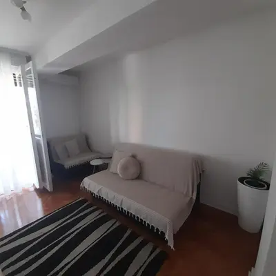 a white living room with a couch and a rug at Apartman Mika **Centar ** in Kruševac