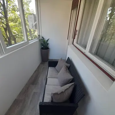a living room with a couch and two windows at Apartman Mika **Centar ** in Kruševac