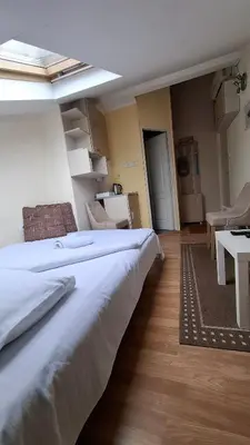 a large white bed in a room with a kitchen at Happy moment Niš in Niš