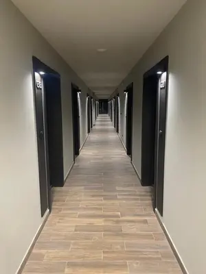 a long hallway with black doors and a tile floor at Bela Reka C320 Kopaonik Brzece in Brzeće