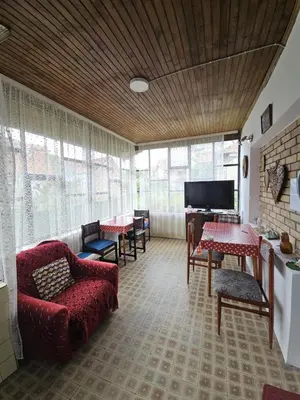 a living room with a red couch and chairs and a television at VILA MILA SOKOBANJA in Soko Banja