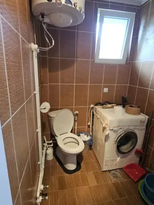 a bathroom with a toilet and a washing machine at VILA MILA SOKOBANJA in Soko Banja