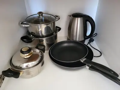 a stove top with a pan and a tea kettle at Kloudscape Apartman Milmari Resort & Spa in Kopaonik