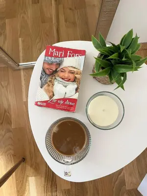 a book and a cup of coffee on a table at Niš East gate APT with balcony and free private Parking in Donja Vrežina