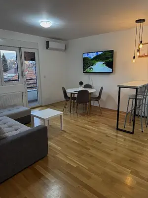 a living room with a couch and a table at Niš East gate APT with balcony and free private Parking in Donja Vrežina