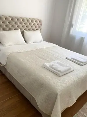 a bed with two white towels on top of it at Woody apartman in Vrnjačka Banja